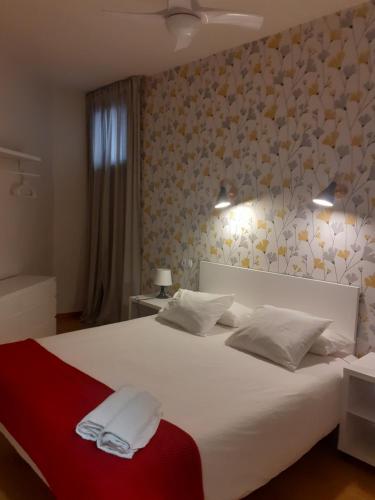 Un dormitorio con una cama blanca con dos toallas encima. en VIVIENDA LA ESTRELLA, en Tudela