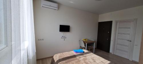 a bedroom with a bed and a tv on the wall at Apartments Swan Lake in Kyiv