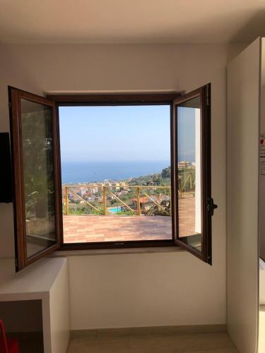 a window in a room with a view of the ocean at mammaCristina in Patti