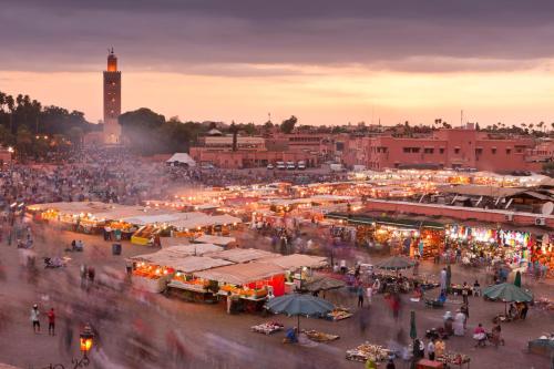 a crowd of people walking around a market at night at La Sultana Marrakech in Marrakesh