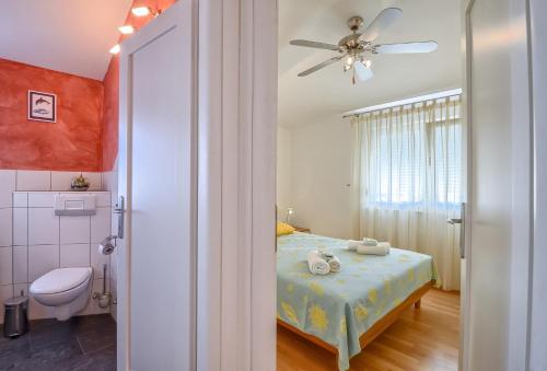 a bedroom with a bed and a ceiling fan at Apartman Maksim in Banjole