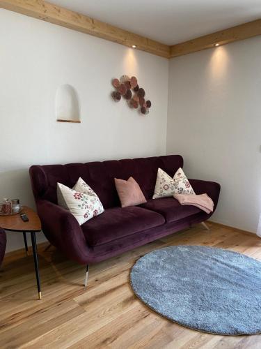 a living room with a purple couch and a blue rug at Neurenovierte Ferienwohnung Franzl in Holzkirchen