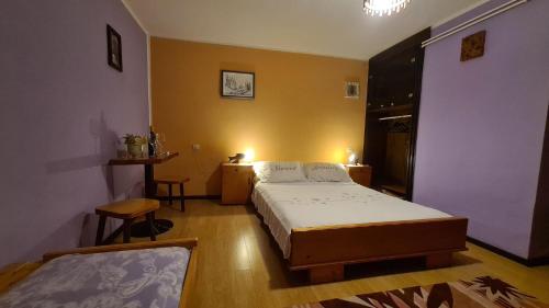 a bedroom with a bed and a table and chairs at Apartman Štimac in Crni Lug