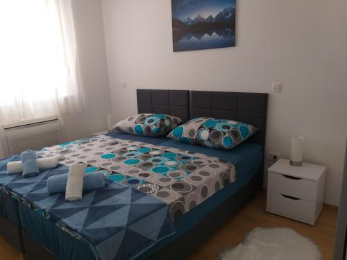 - une chambre avec un lit doté d'une couette et d'oreillers bleus dans l'établissement Apartment T&T Višnjik, à Zadar