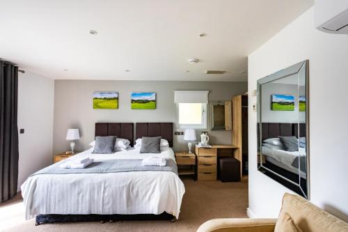 a bedroom with a large bed and a mirror at The Vale Golf & Country Club in Bishampton