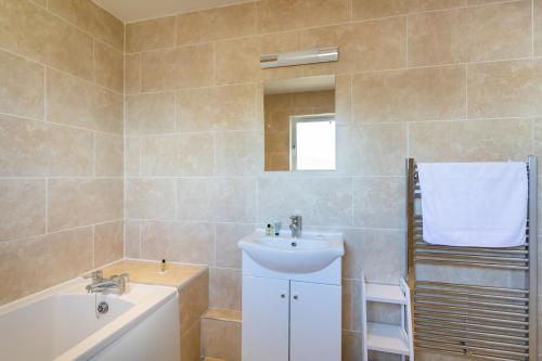 a bathroom with a sink and a bath tub at The Vale Golf & Country Club in Bishampton