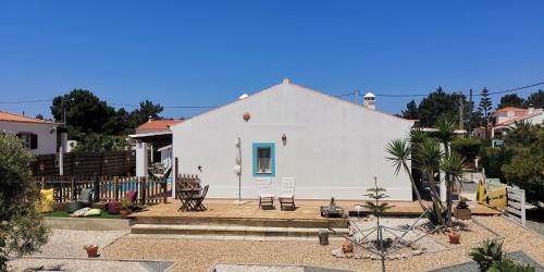 
a white house with a blue roof and a white building at Maravilha da Costa in Aljezur
