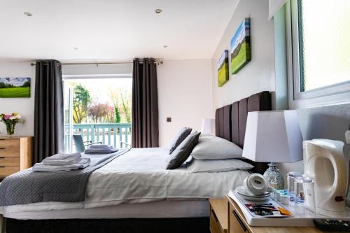 a bedroom with a large bed and a window at The Vale Golf & Country Club in Bishampton