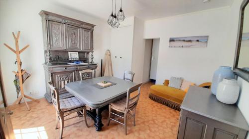 une cuisine et un salon avec une table et un canapé dans l'établissement Charmante maison de ville avec jardin - 2 chambres - 5 pers, à Saint-Jean-de-Monts
