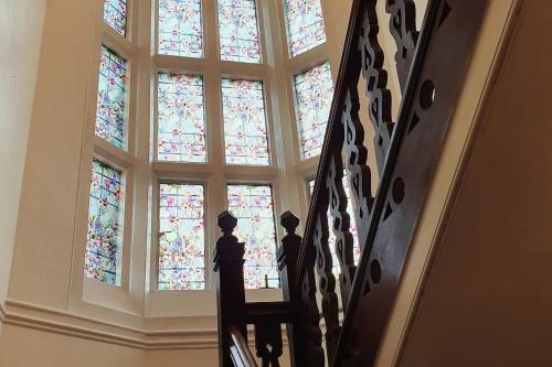 a staircase with stained glass windows in a building at Country Manor House with indoor pool and hot tub in Rochester