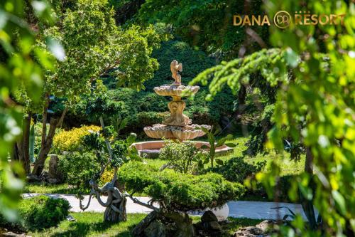 a fountain in the middle of a garden with trees at Hotel Dana Resort in Venus