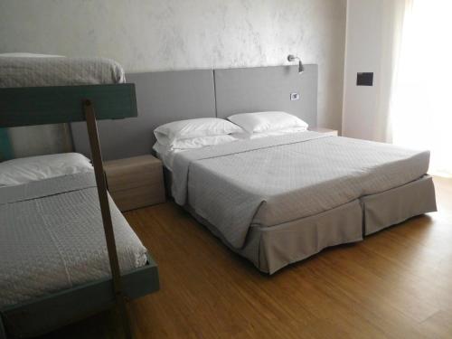 a bedroom with a bed and two bunk beds at Hotel Emperador in Lido di Jesolo
