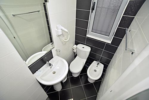 mała łazienka z umywalką i toaletą w obiekcie SunRise Suites we Wlorze