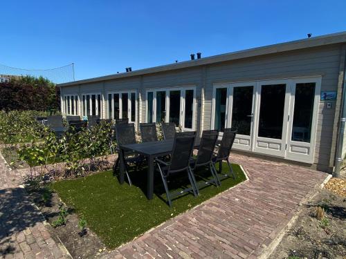 a patio with a table and chairs in front of a building at Polderlodge in Hillegom