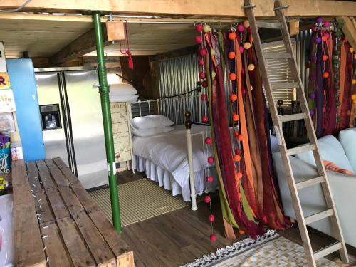 a room with a bunk bed and a ladder at The Wackery in Chiddingfold