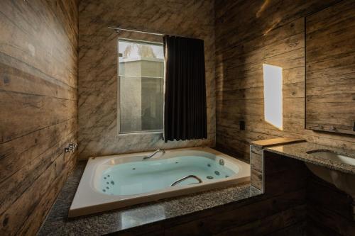 普雷圖河畔聖若澤的住宿－Drops Motel São José do Rio Preto，一间带按摩浴缸和水槽的浴室
