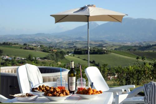 a table with bottles of wine and bowls of fruit at Residence Borgo Offida in Offida
