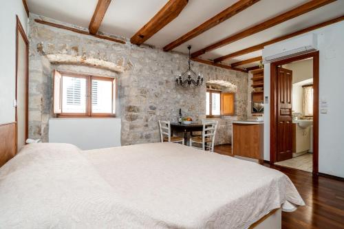 a bedroom with a large bed and a kitchen at Apartments Martecchini in Dubrovnik