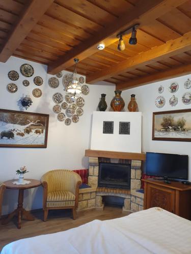 a bedroom with a fireplace and plates on the wall at Kulacs Csarda Panzio in Eger