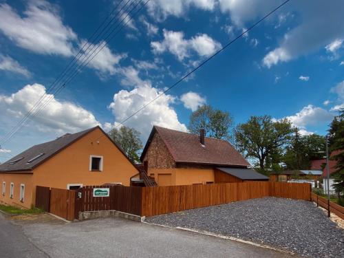 a house with a wooden fence in front of it at Ubytování Smrk in Nové Město pod Smrkem