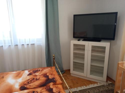a flat screen tv sitting on top of a white cabinet at Luxury Eagle apartman in Budapest