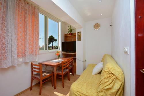 salon z kanapą, stołem i oknem w obiekcie Apartment with large terrace 3558-4 w mieście Žuljana