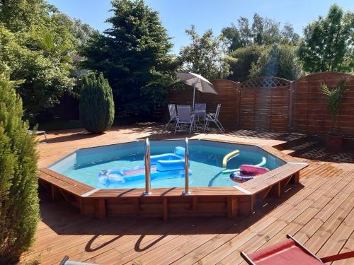 a pool on a wooden deck with at Le Figuier in Le Lindois