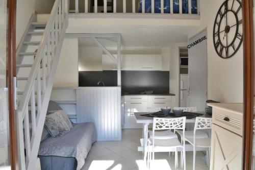 - un salon avec un escalier, une table et des chaises dans l'établissement LES PATIOS DE LA MER : villa 4 pers proche de la plage, à Saint-Cyprien