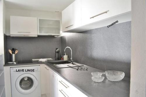 une cuisine avec un évier et une machine à laver dans l'établissement LES PATIOS DE LA MER : villa 4 pers proche de la plage, à Saint-Cyprien
