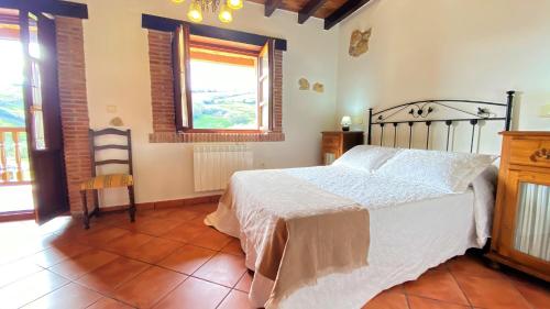 a bedroom with a bed in a room with a window at La Helguera Vivienda Vacacional in Villanueva
