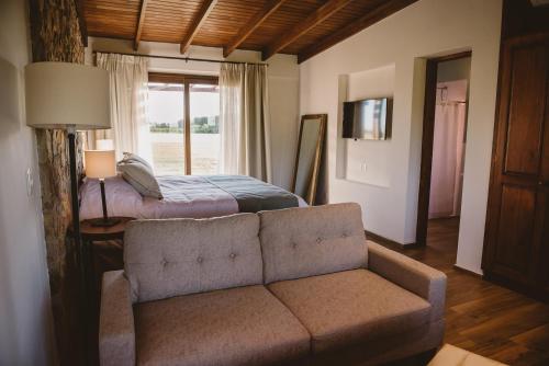 a living room with a couch and a bed at El Legado Wine Lodge in Carmelo