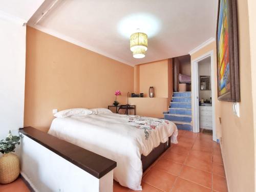 トレモリノスにあるapartamento carihuelaのベッドルーム1室(大型ベッド1台、階段付)