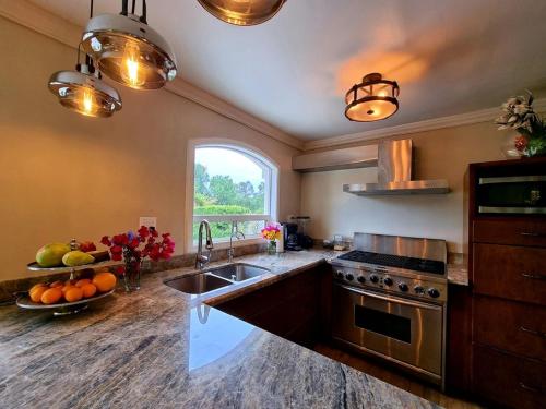 a kitchen with a sink and a stove and a window at La Casa Rosa in Ensenada