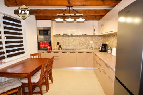 a kitchen with a wooden table and a dining room at Cabana Andy in Rausor