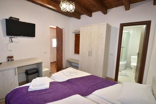 a bedroom with a bed and a tv on the wall at Cabana Andy in Rausor