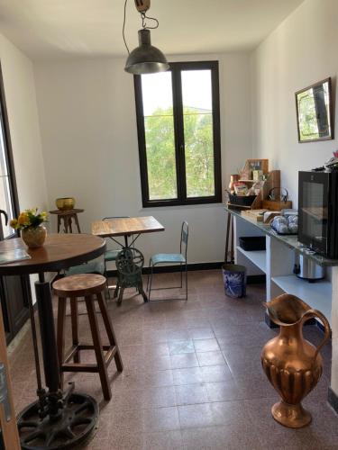 Una habitación con una mesa y sillas y una cocina. en Hôtel La Demeure Coloniale, en Moriani Plage