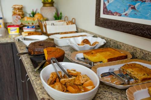 un contatore ricoperto da molti tipi di alimenti diversi di Hotel Della Vita a Glória de Dourados