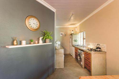 une cuisine avec une horloge murale dans l'établissement Steenbok farm cottages Aalwyn Cottage, à Wolseley