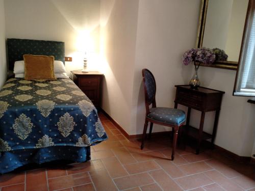 ピエンツァにあるSmall lovely home in Pienzaのベッドルーム1室(ベッド1台、椅子、テーブル付)