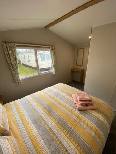 a bedroom with a bed and a window at Willerby Grasemere Lochlands Leisure Park Forfar in Forfar