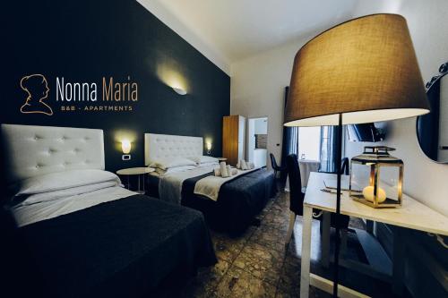 una habitación de hotel con 2 camas y una lámpara en Bed And Breakfast Nonna Maria, en Taranto