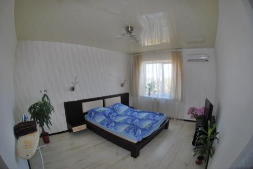 a bedroom with a bed with a blue comforter at Квартира в центре Черемушек in Odesa