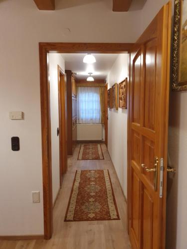 a hallway with a door and a rug on the floor at Kulacs Csarda Panzio in Eger