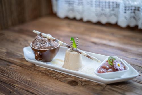 a plate with two desserts on a wooden table at Gasthof Post in Rennweg