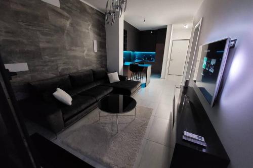 un salon avec un canapé noir et une table dans l'établissement Luxury Penthouse Sarajevo, à Sarajevo