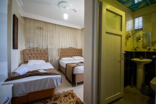 a bedroom with two beds and a bathroom with a sink at Ozyurt Hotel Istanbul - Old City in Istanbul