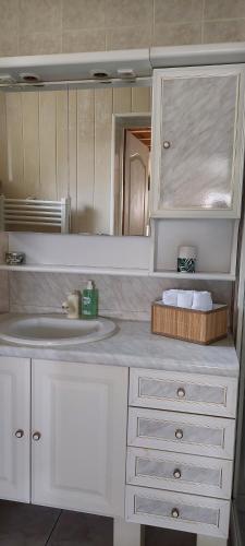 Baño blanco con lavabo y espejo en Maison de vacances, en Montgesoye