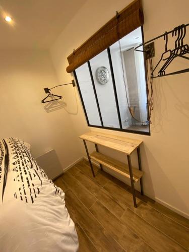 une chambre avec un lit, une table et une fenêtre dans l'établissement Charmant Appartement quartier Opéra, à Toulon