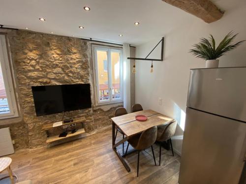 une cuisine avec une table et un réfrigérateur dans l'établissement Charmant Appartement quartier Opéra, à Toulon