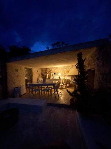 a table and chairs on a patio at night at Pietrefitte in Ostuni